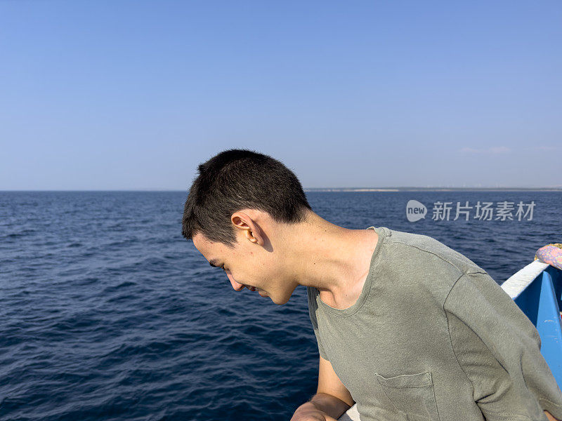 这个男孩正在北爱琴海的一艘男孩游船上旅行。体贴又快乐。晴朗的夏日。旅游的背景。旅游的概念。