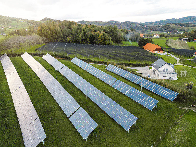 从空中俯瞰葡萄园附近的小山上的乡村太阳能农场。光伏太阳能电池板是绿色能源。