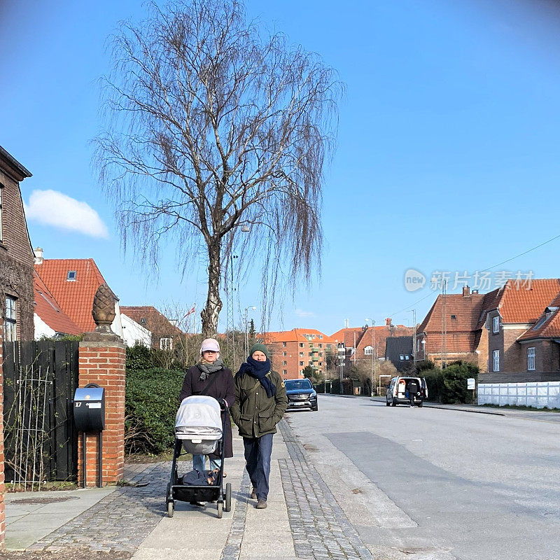 一对夫妇推着婴儿车在丹麦哥本哈根散步。