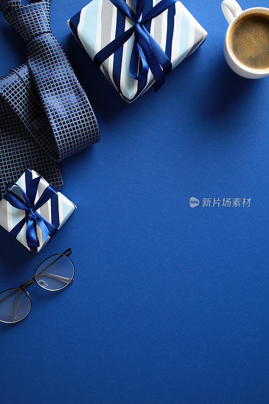 在充满活力的蓝色背景上，以礼物、领带、眼镜和一杯咖啡为特色的平面构图。理想的主题有关的业务，礼品，或庆祝。