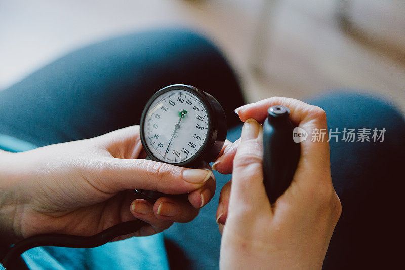 妇女在家里用机器测量血压