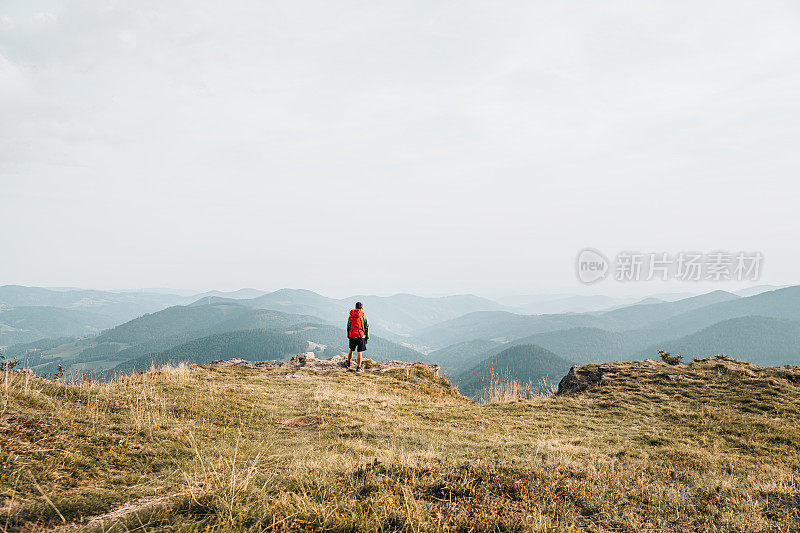 徒步旅行者在长满草的山脊上放松的观点