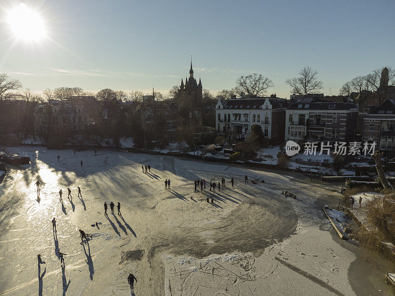 在美丽的冬日里，人们在结了冰的兹沃勒运河上滑冰