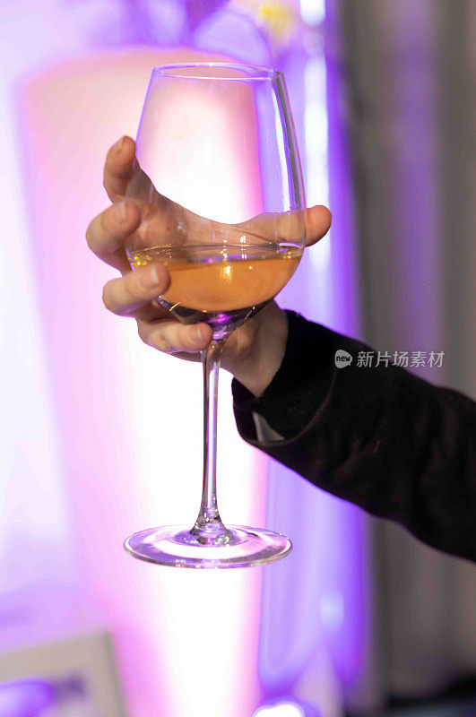 在周六晚上的派对或活动上，女人拿着一杯酒。