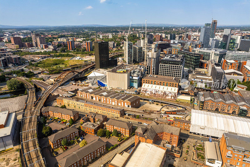 英国曼彻斯特的空中拍摄的现代建筑，在城市的中心地区有很多建设，前景是历史运河和铁路