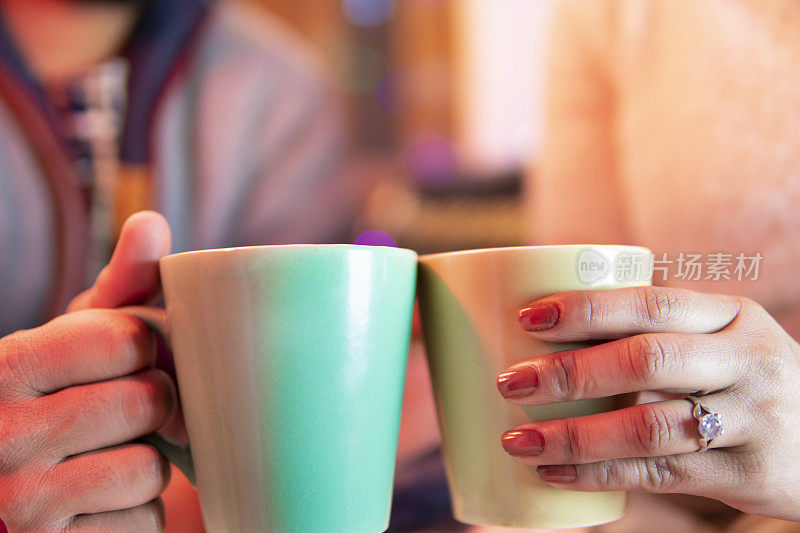 一对情侣手握咖啡杯共度时光的特写镜头。