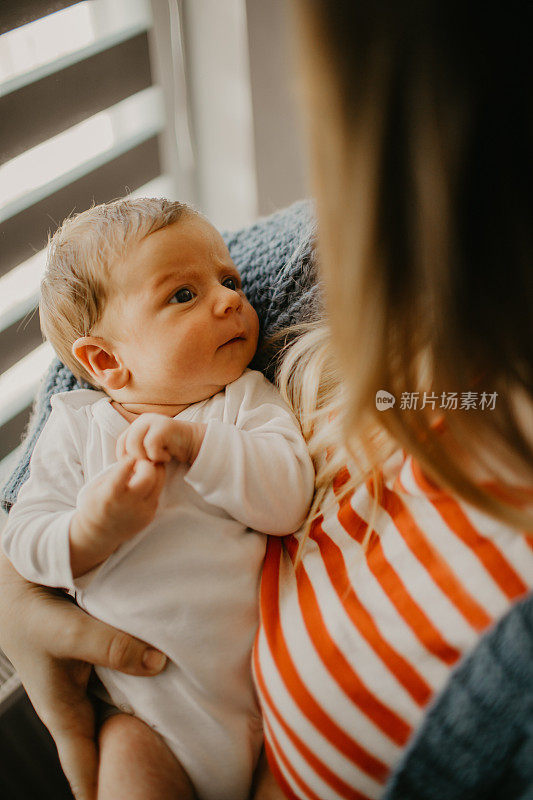 一个刚出生的男婴在他母亲的怀里