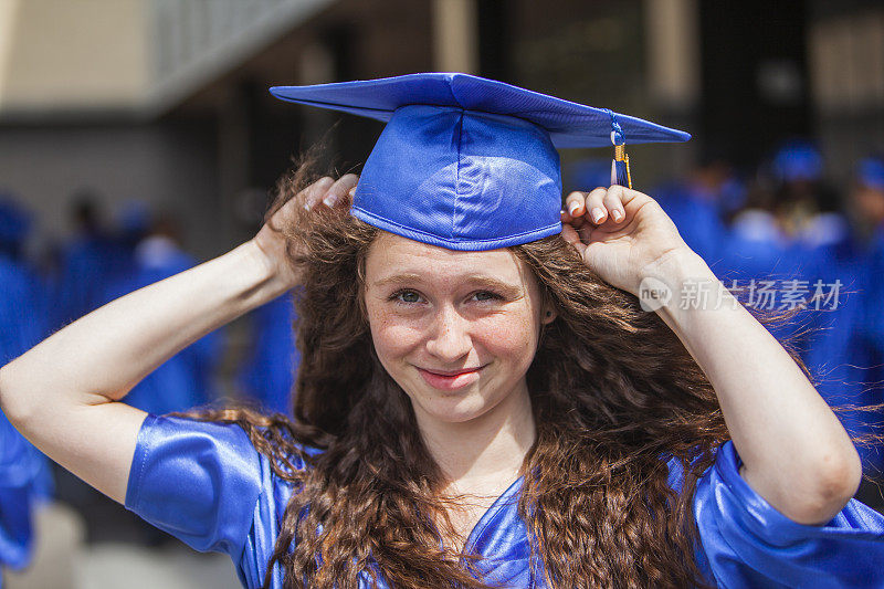 一个女孩正在拿中学毕业证书。