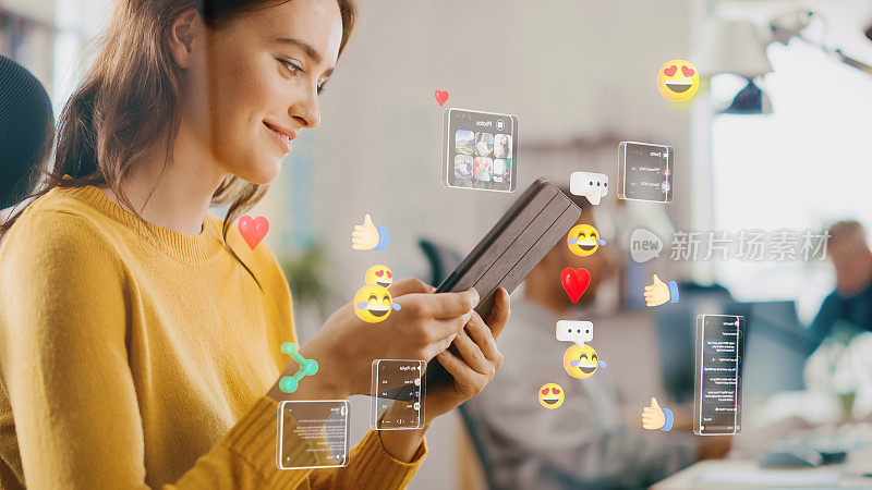 社交媒体可视化概念:快乐的年轻女子在办公室使用数字平板电脑，社交媒体帖子，笑脸，电子商务在线购物数字图标在设备周围飞舞