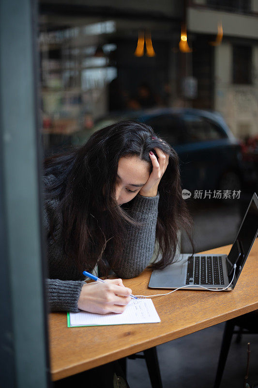 女高中生正在咖啡店学习。