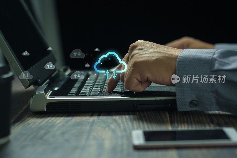 专业商务人士在笔记本电脑上用手敲击电脑键盘，在现代办公场所图云计算云技术存储网络和互联网的概念