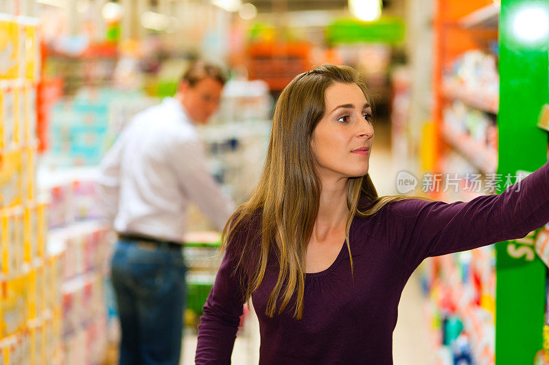 男男女女推着购物车在超市里