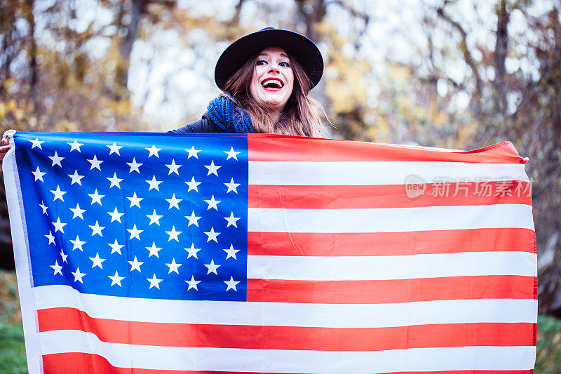 快乐的女人举着美国国旗
