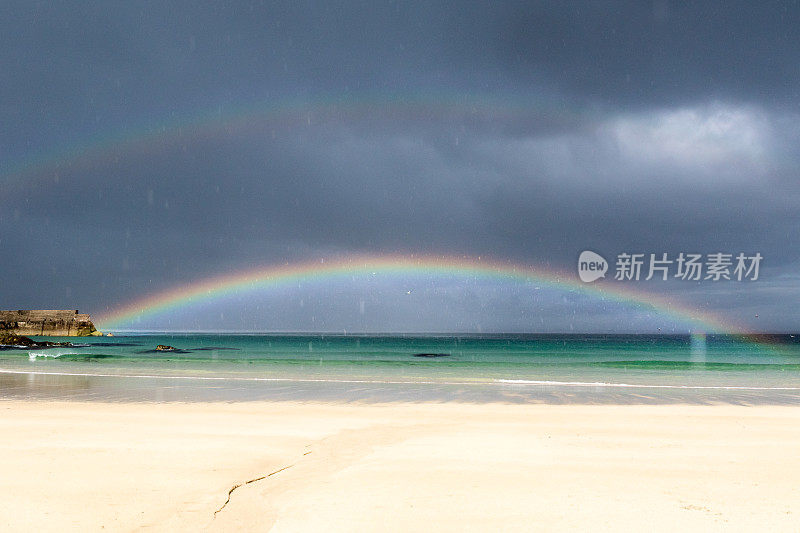 双虹在绿色的海洋和白色的沙滩