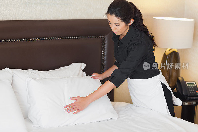 安静的酒店服务员在整理枕头