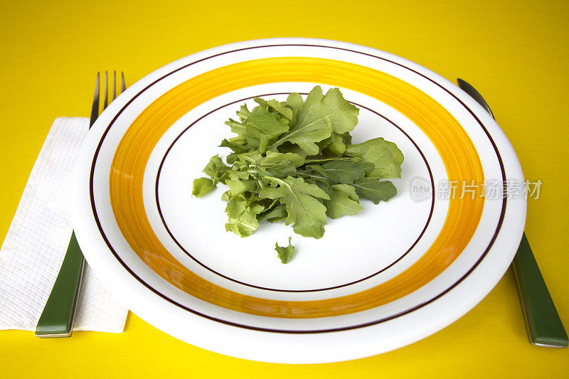 大餐盘上的芝麻菜，黄色背景