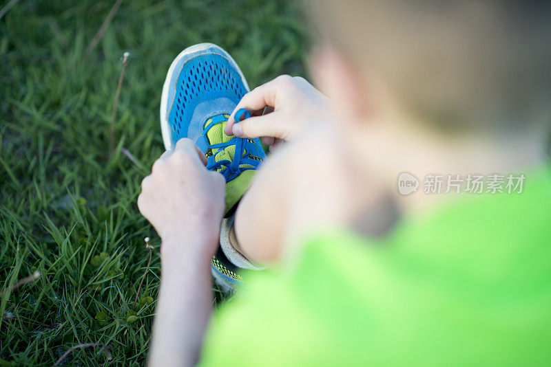 系鞋带的小男孩