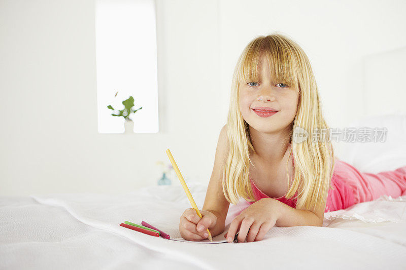 女孩躺在床上画画