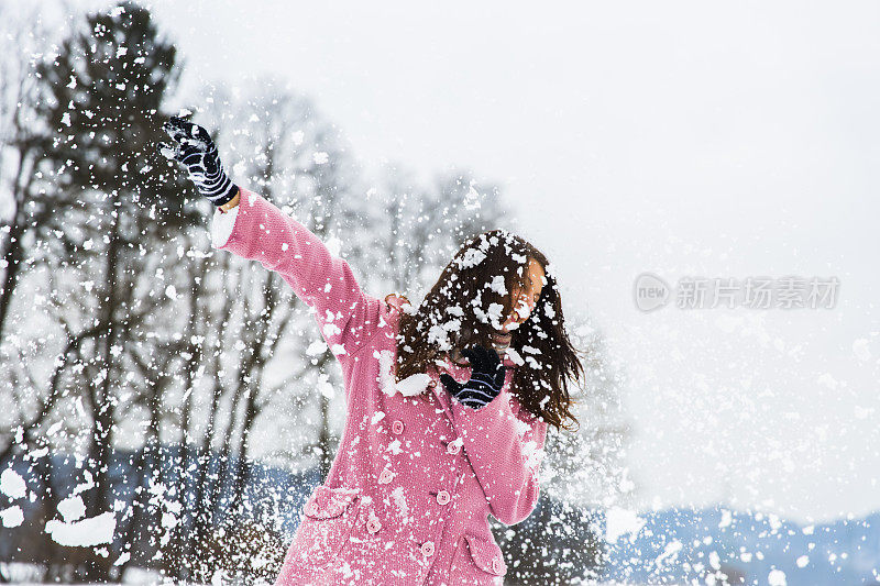 可爱的年轻女子被雪球砸中了