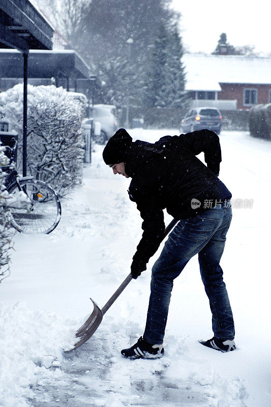 在人行道上铲雪的人