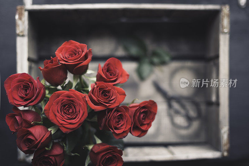 一束红玫瑰放在上面的乡村木箱里