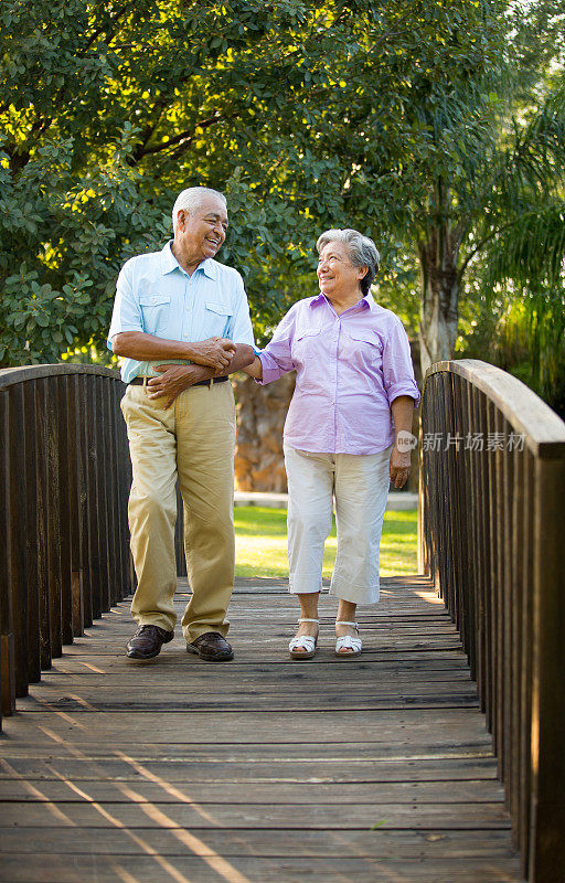 一对老年夫妇在桥上散步