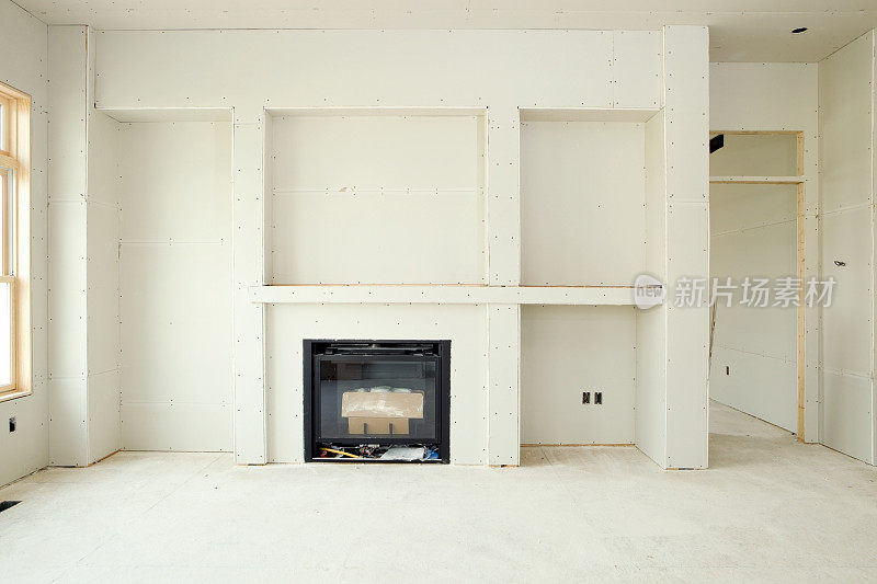 带有壁炉和嵌入式书架的新客厅石膏板墙