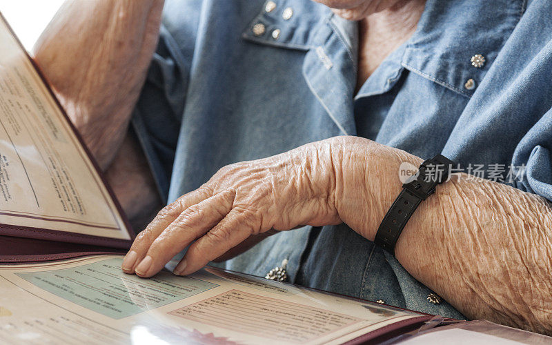 触摸和阅读餐厅菜单的老妇人