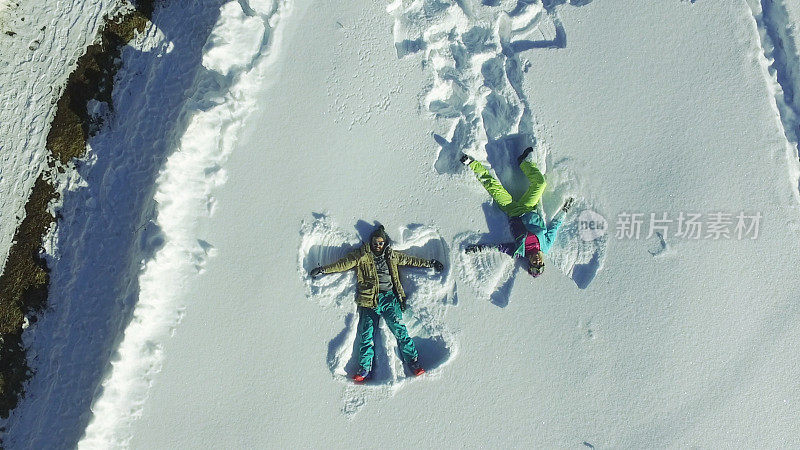 一对夫妇在雪中制作天使剪影