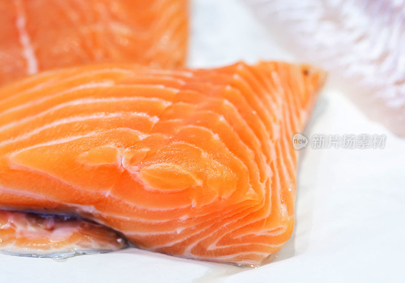 新鲜生鲑鱼片在海鲜市场展示。