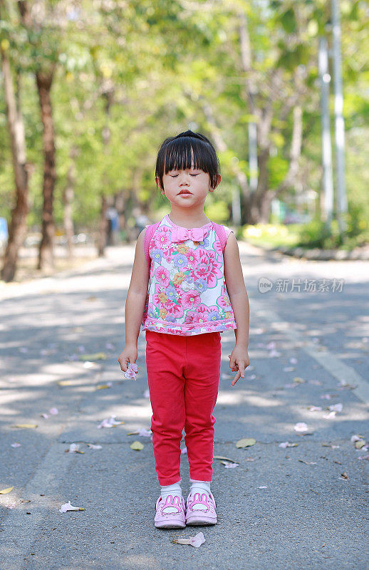 可爱的小女孩平静地在公园里的肖像。