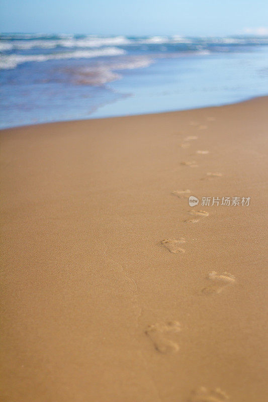 沙滩上的脚印通向大海