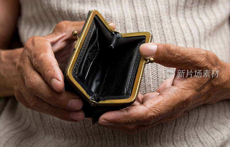 一个老人拿着一个空钱包。退休后贫困的概念。