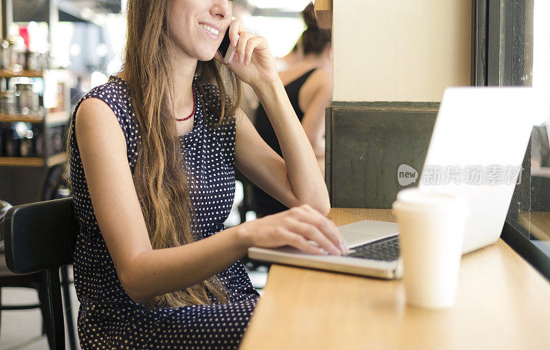 一个在咖啡馆用笔记本电脑工作的女人