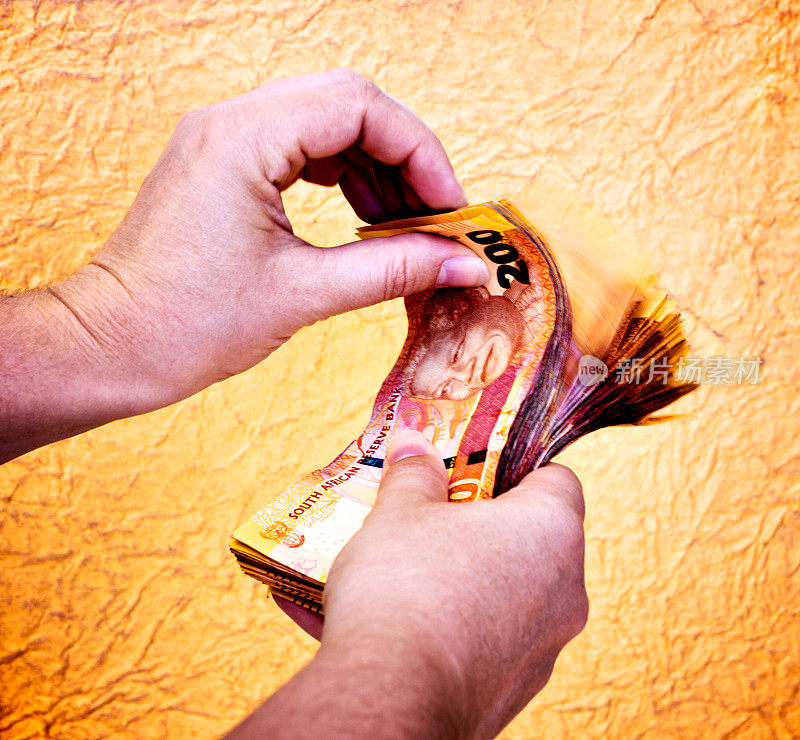 女性的手在数着厚厚的南非钞票