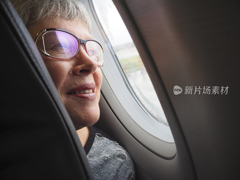从飞机的窗口往外看的女人