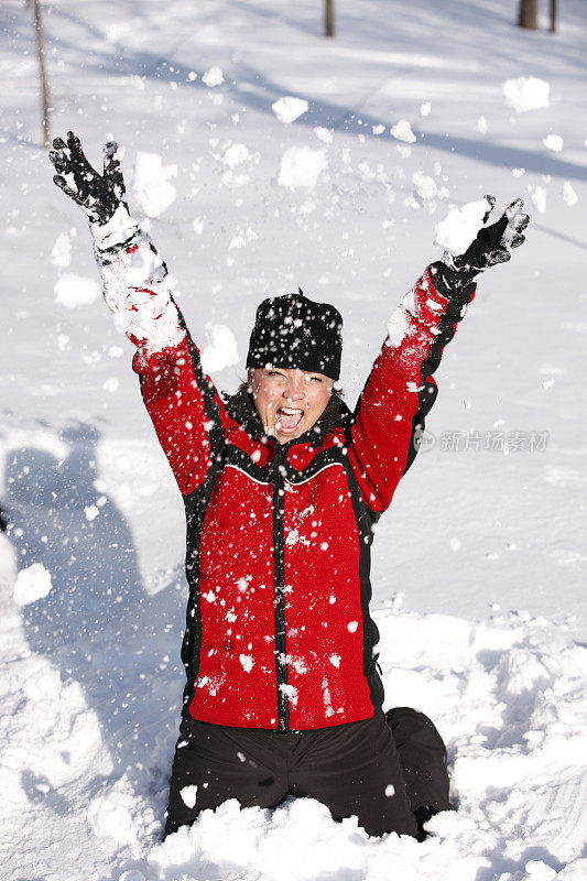 成熟的女人在雪地里玩。