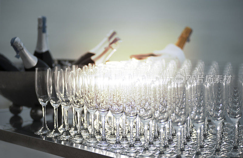 在日落的豪华海滩宴会上的葡萄酒杯和葡萄酒瓶。