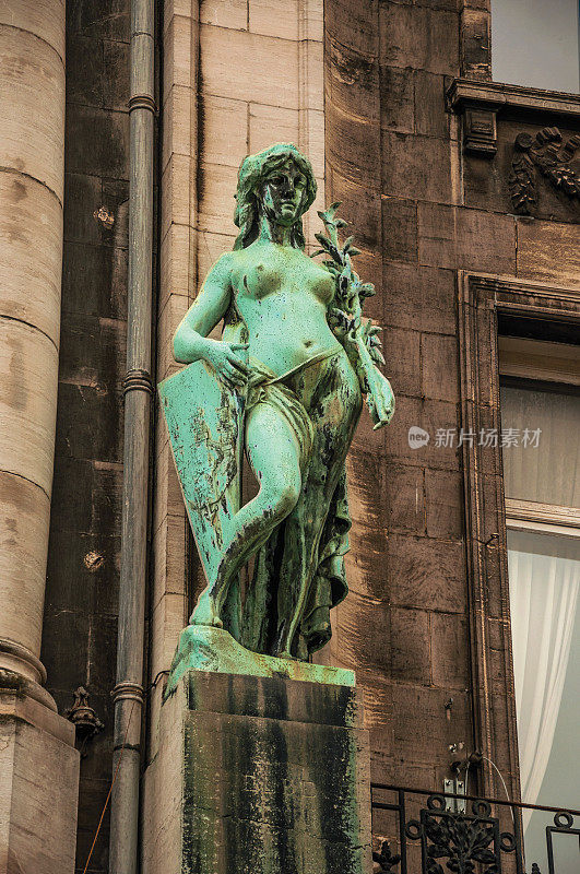 安特卫普阴天里一座建筑里的女性雕像的特写镜头。