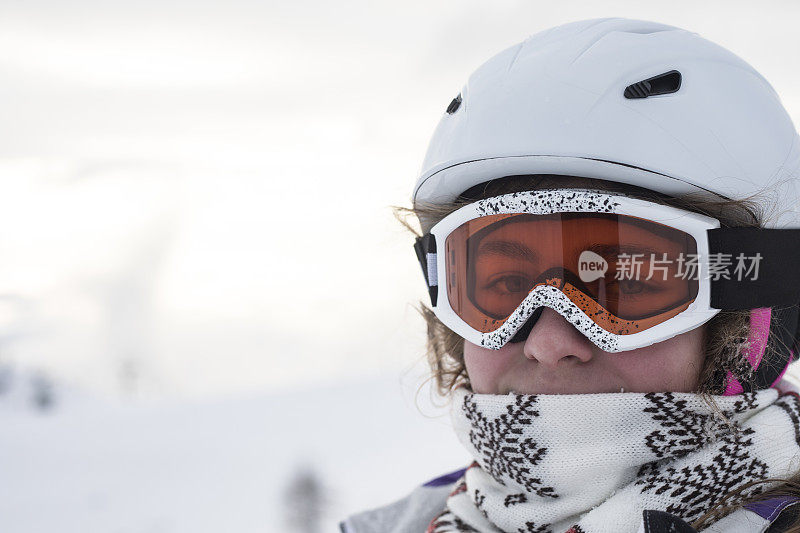 十几岁的女孩滑雪者在滑雪坡上看着相机