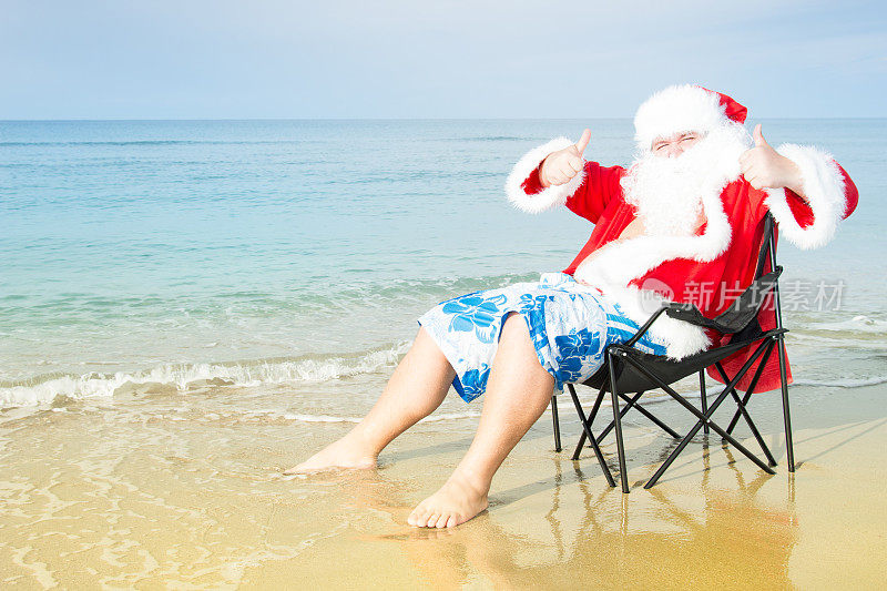 海滩上穿着短裤的有趣圣诞老人。