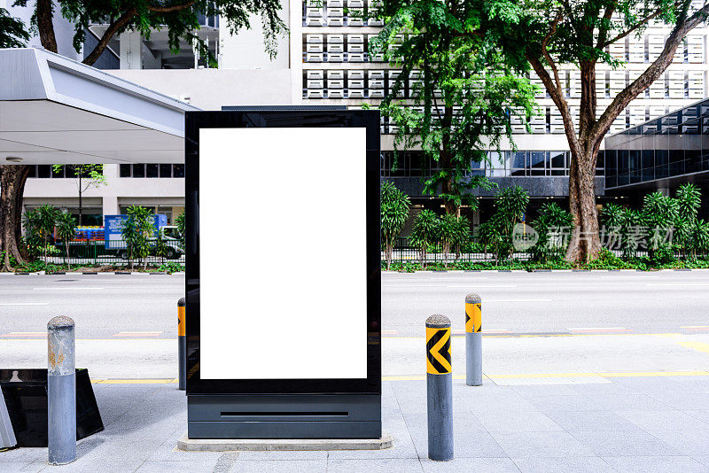 阳光普照的街道上，公共汽车站上的广告牌上挂着空荡荡的广告横幅。