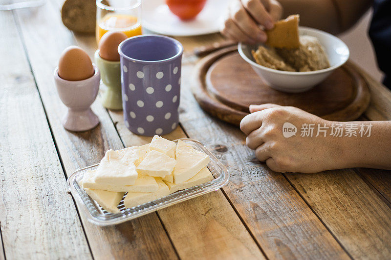 早餐在餐桌上-煮鸡蛋，摩泰台拉，软奶酪，酸奶和果汁