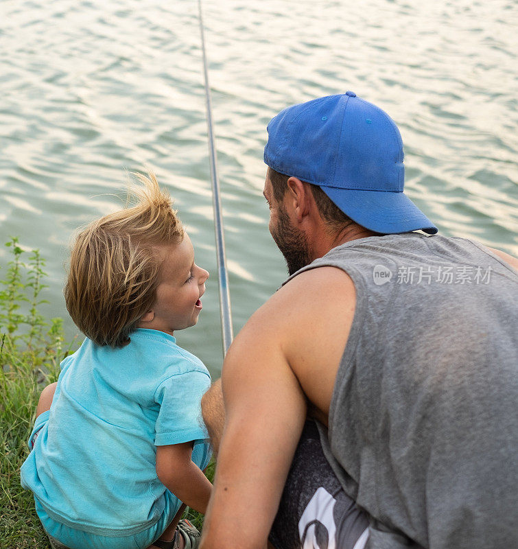 快乐的爸爸和他的小儿子钓鱼