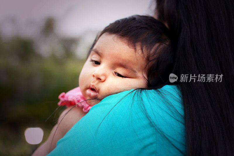 可爱的婴儿睡在妈妈的肩膀上