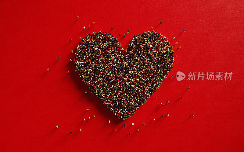 人群在红色背景上形成一个大的心形:爱与捐赠的概念