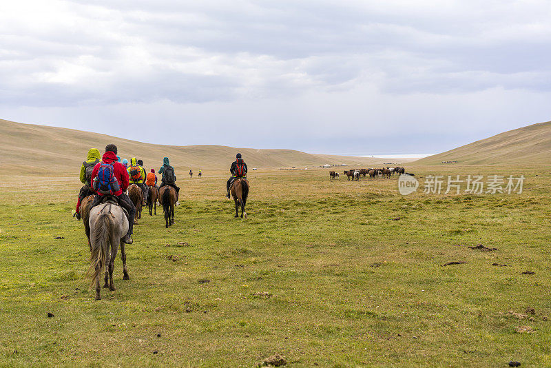 一大群骑马旅游的游客前往吉尔吉斯斯坦的松科尔湖