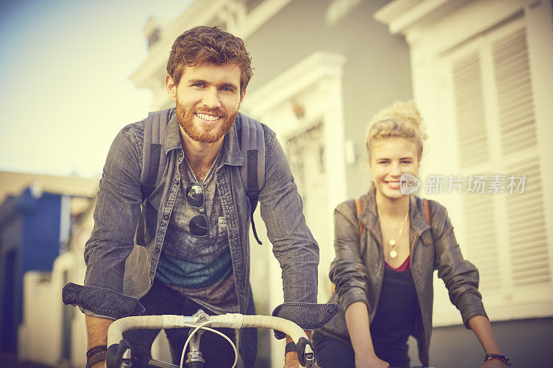 一对年轻夫妇在城市里骑自行车
