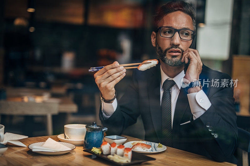 在寿司店打电话的男人