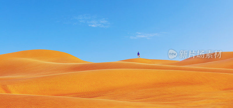 一个人在亚洲美丽的红色沙丘上-旅游探索独自沙漠在迪拜-发现地球概念全景与人徒步旅行